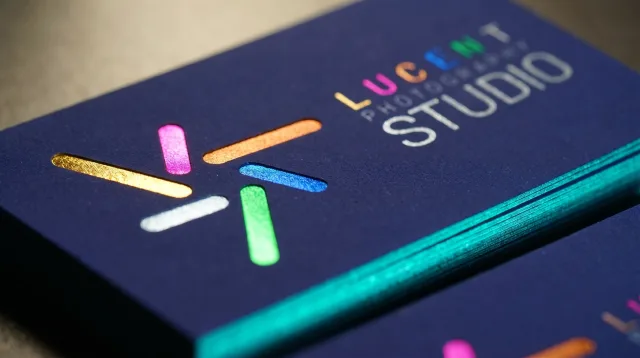 Navy card with gold, pink, copper, blue, green, and silver foil detail and a teal foiled edge.