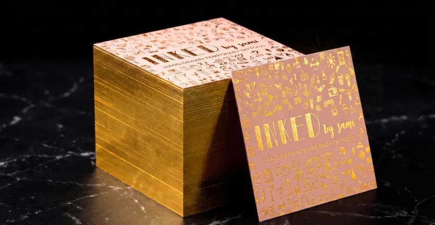 Square business cards with gold foil with gold foil edges.