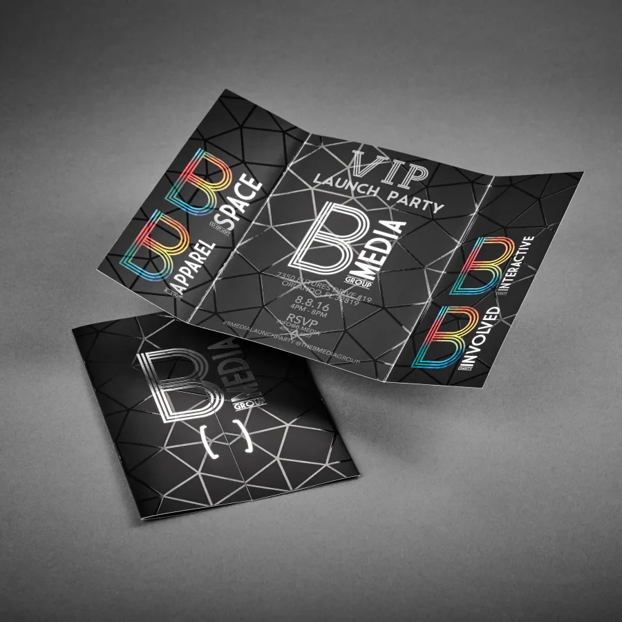 A black trifold brochure for B Media Group displays a geometric pattern with rainbow foil lettering and spot UV highlights in a glossy finish.
